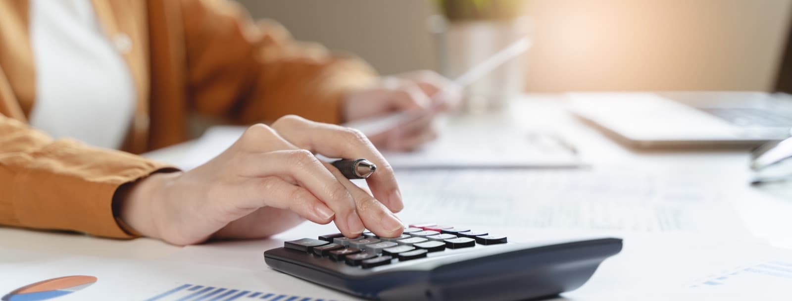 Warm home office with a calculator and financial materials